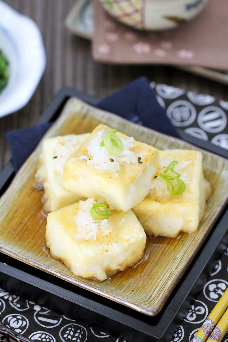Knusprig frittierte Tofustücke in Dashi-Brühe, garniert mit geriebenem Daikon und Frühlingszwiebeln.